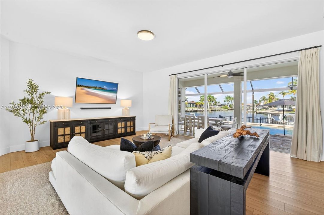 Living room with gorgeous water views & triple stacking sliders to covered enclosed patio