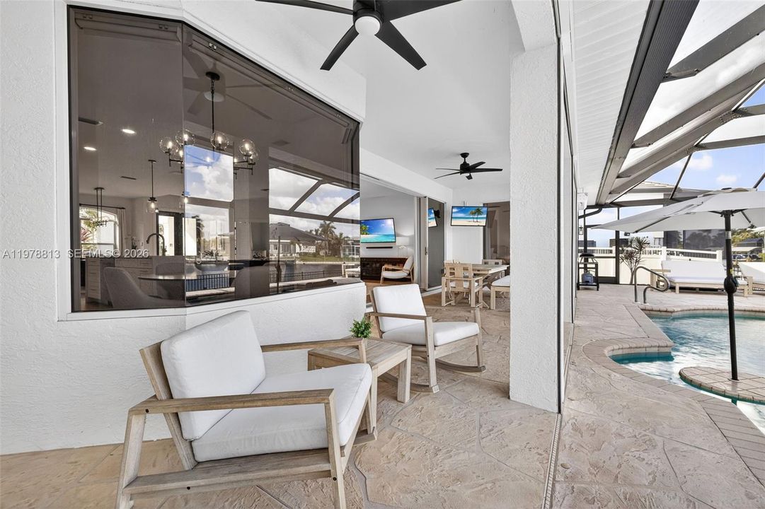 Covered lanai, ceiling fans, an outdoor heated pool w/new pool pump (2026), and an outdoor living / dining area