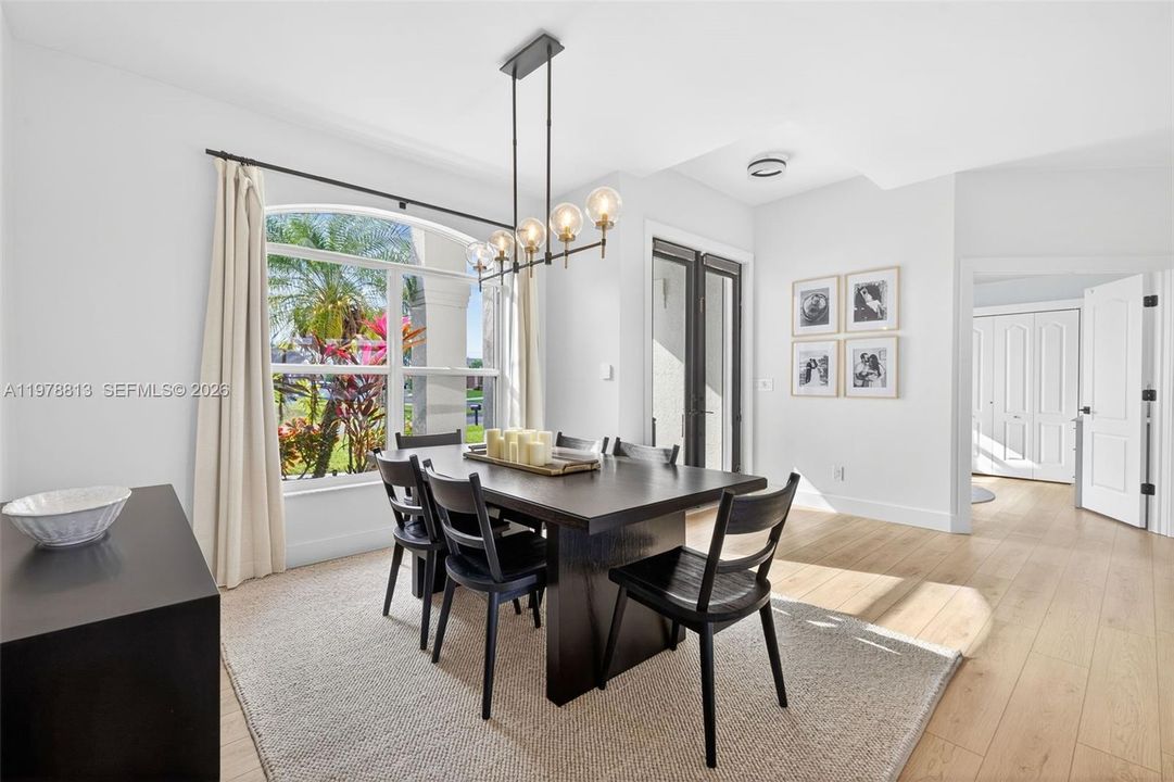 Formal dining area with light wood-style LVP floors and a chandelier