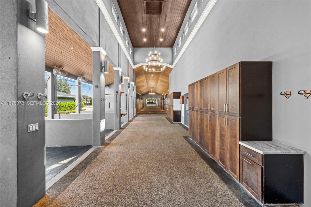 Barn hallway with high tongue & groove ceilings and lockers for supplies.