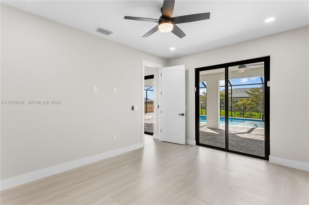 LARGE PRIMARY SUITE w/ sliding doors to lanai, WALK-IN CLOSET w/ BUILT-IN SHELVING & HANGING RACKS