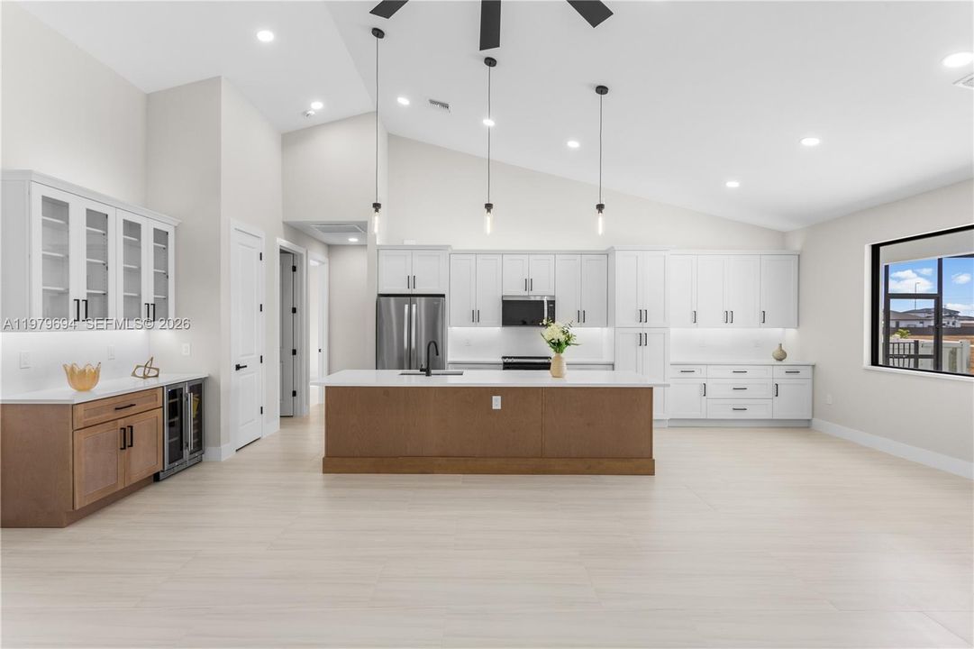Crisp WHITE SHAKER CABINETRY is paired w/ contrasting warm WOOD-TONE ISLAND CABINETS & modern BLACK HARDWARE for a sophisticated coastal-modern design.
