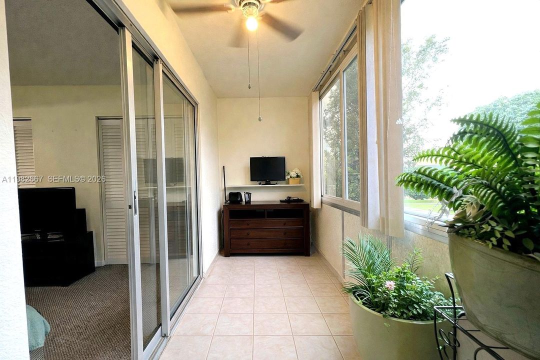Enclosed patio/sunroom overlooking peaceful green space.