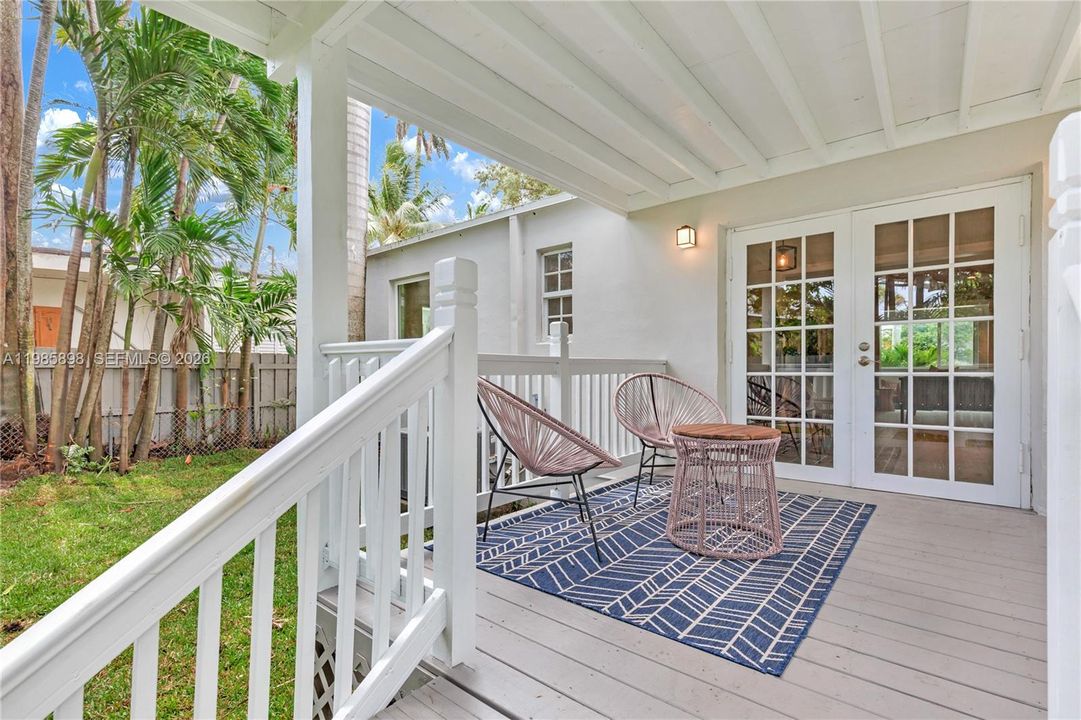 Covered porch with seating area overlooking backyard