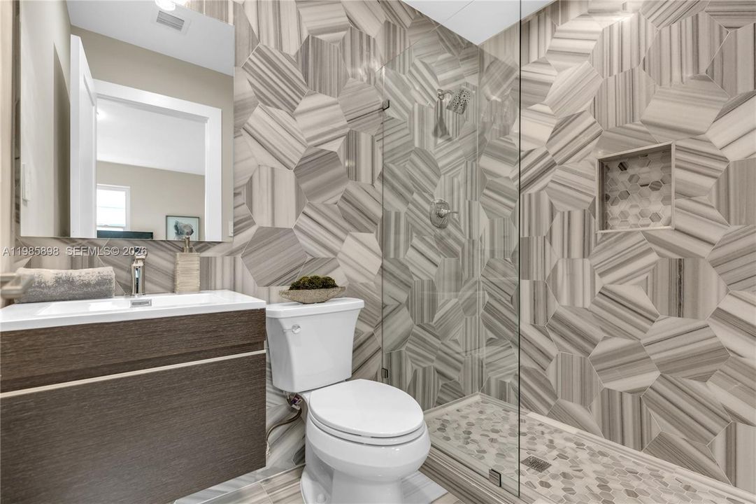 Full bathroom with walk-in shower, shared by second and third bedrooms