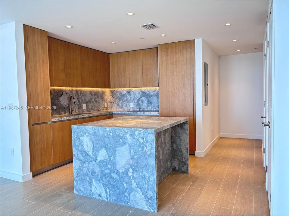 Kitchen with custom island in matching ItalKraft cabinetry and quartzite waterfall
