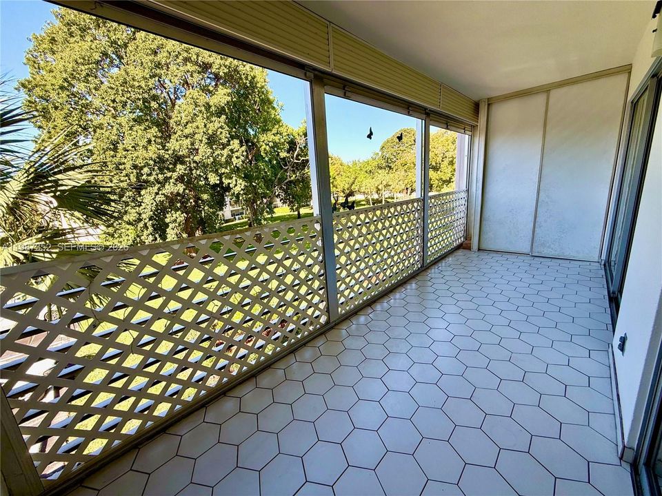 Large screened balcony with 2 sliding glass doors and storage closet