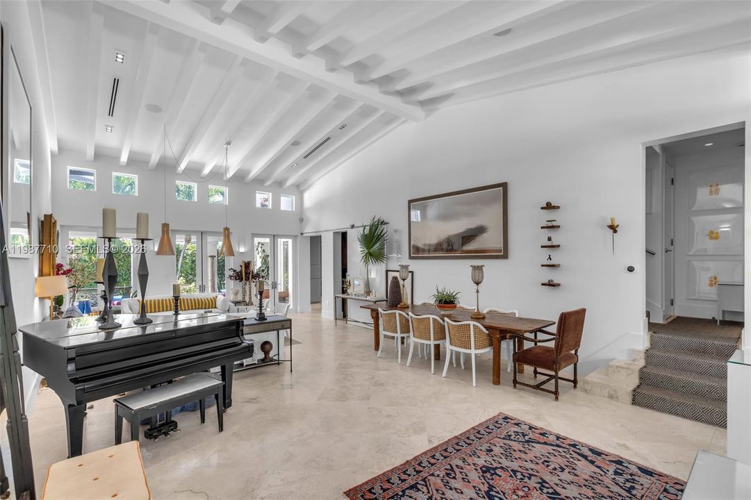 The spacious room features a living room and dining room with vaulted ceilings and high ceilings.