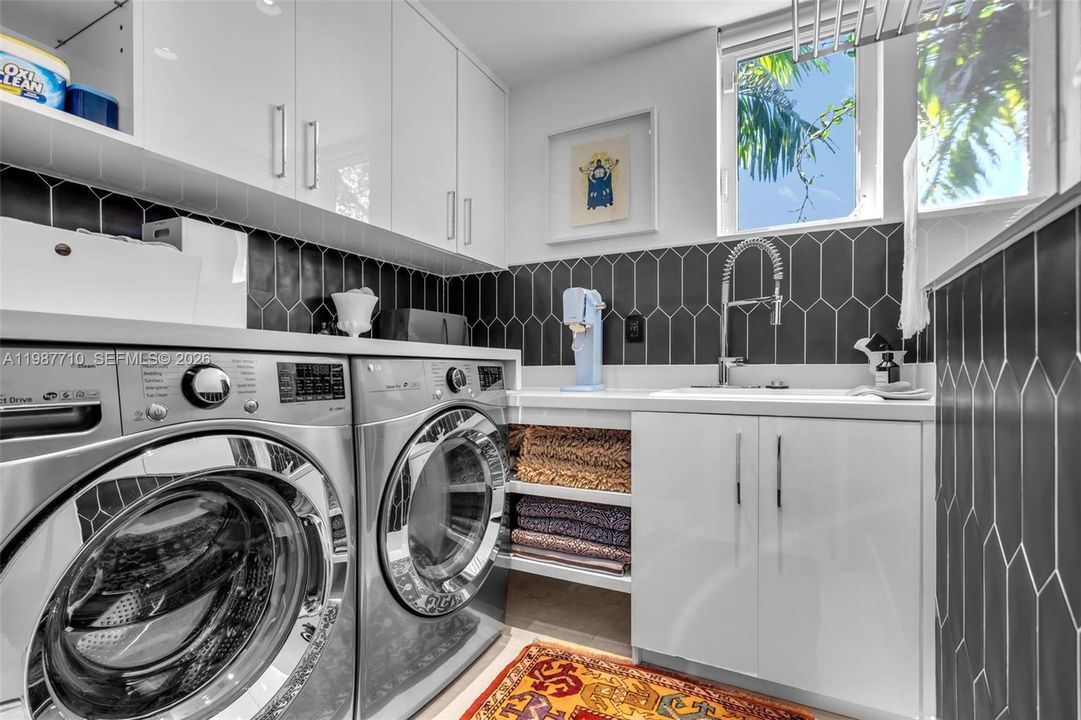 A built-in laundry room fixture, including a water faucet, is installed within the cabinets.