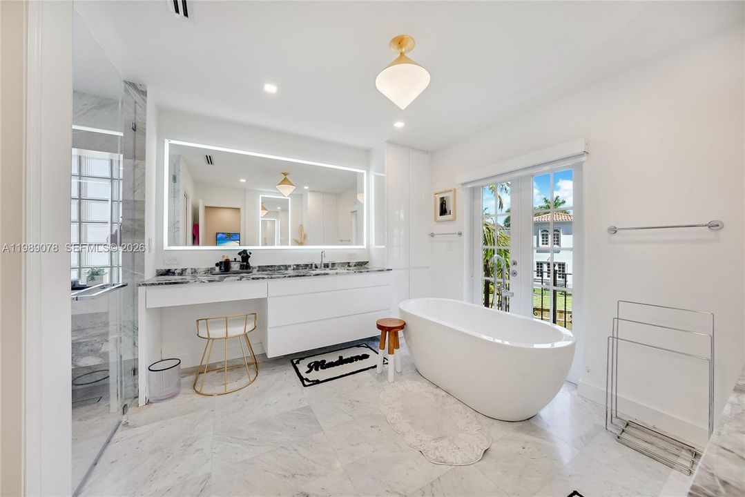 Updated, modern spa like primary bath with marble touches and premium fixtures