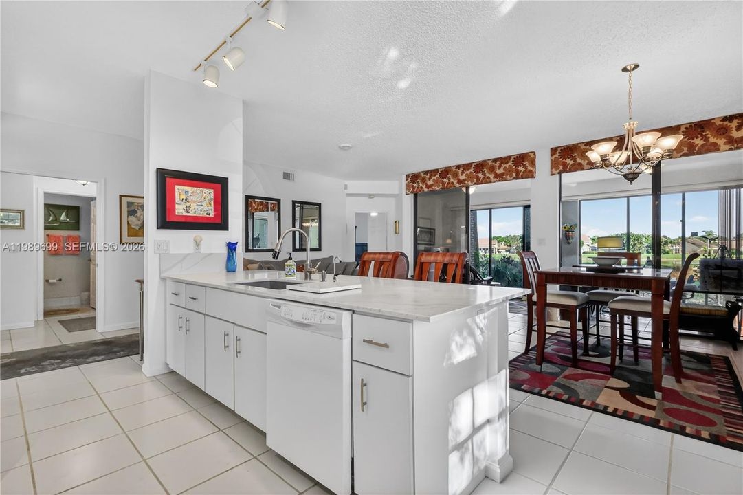 The open kitchen is positioned to capture the tranquil fairway and water views