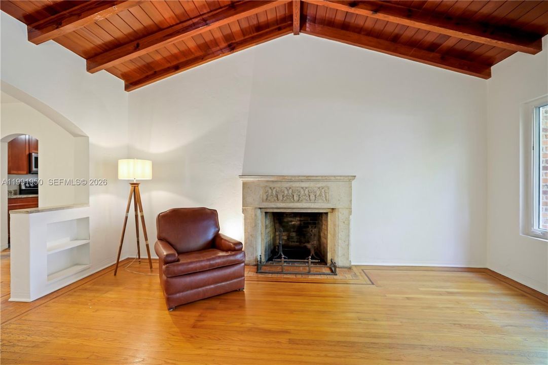 Living room with vaulted wood ceiling, fireplace, and open, airy layout