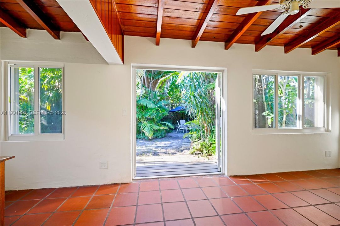 Large open Florida room with abundance of natural light and wood-beam ceiling
