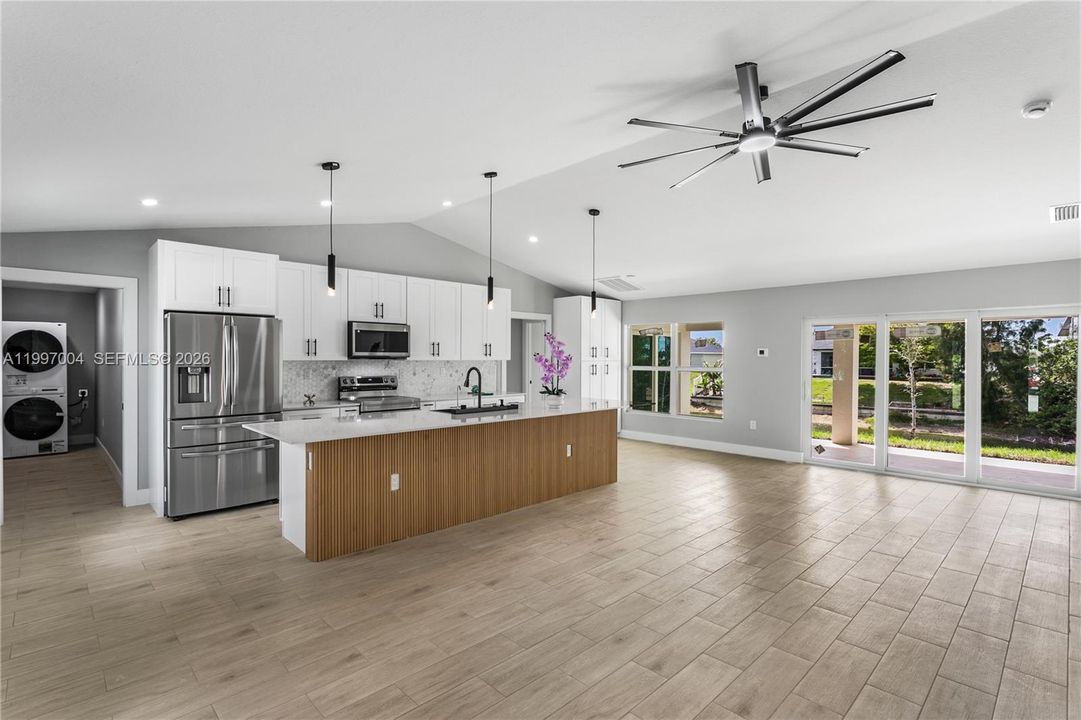 Inside, a bright open-concept floor plan features light neutral tile flooring throughout & impact-resistant windows and sliding doors.