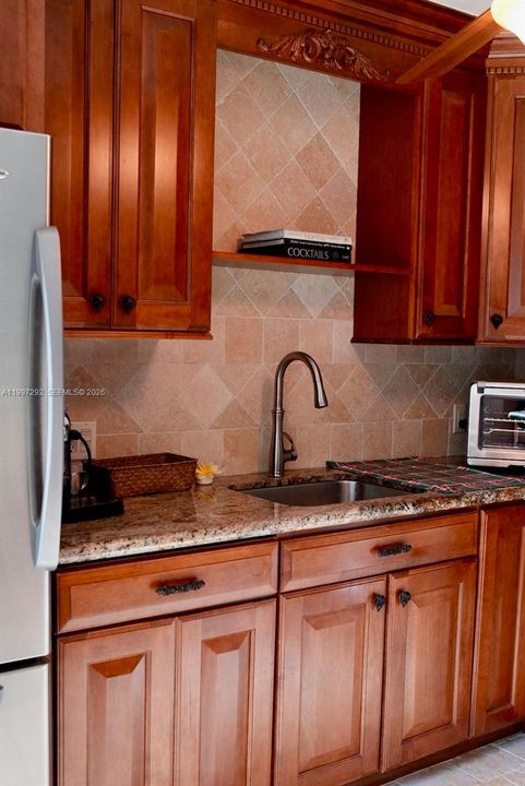 Well maintained custom cabinetry, stone tiles, and high-end appliances