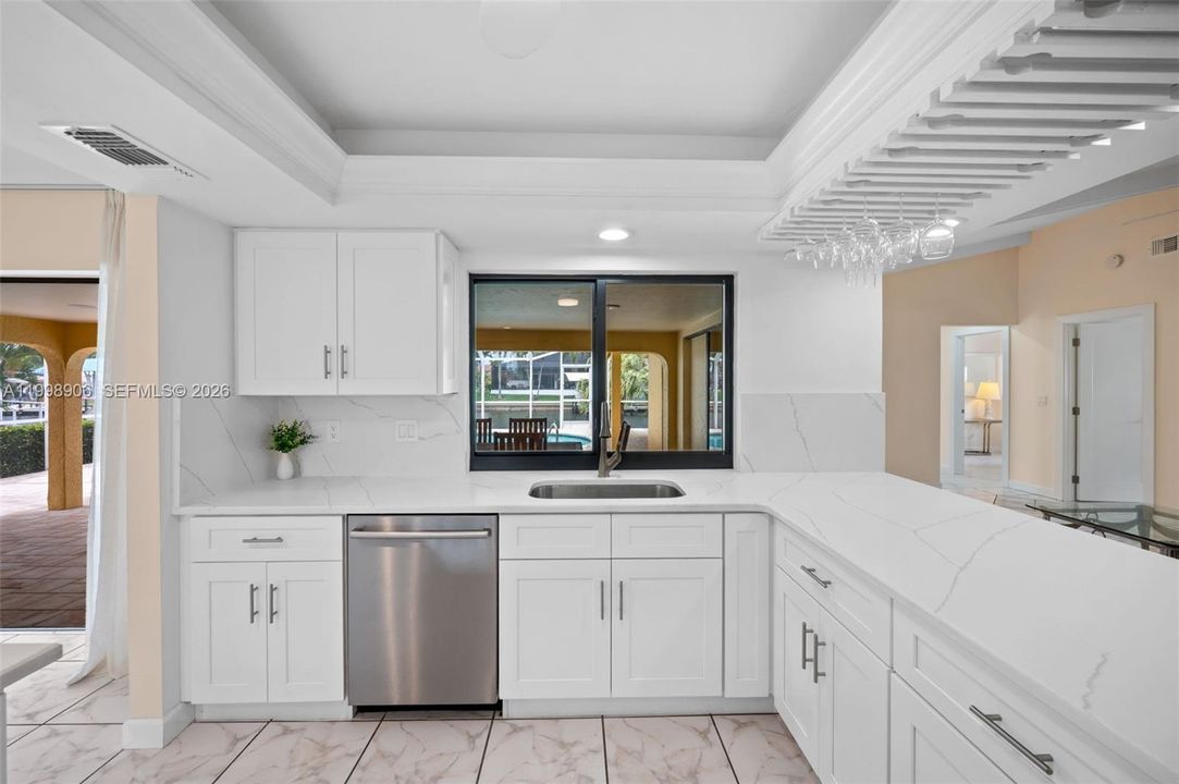 Kitchen overlooks the lanai, pool and canal
