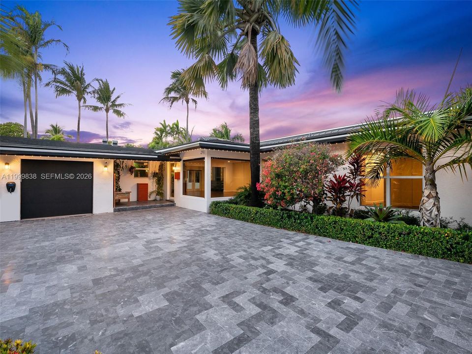Twilight  front of home with stunning landscaping and expansive driveway