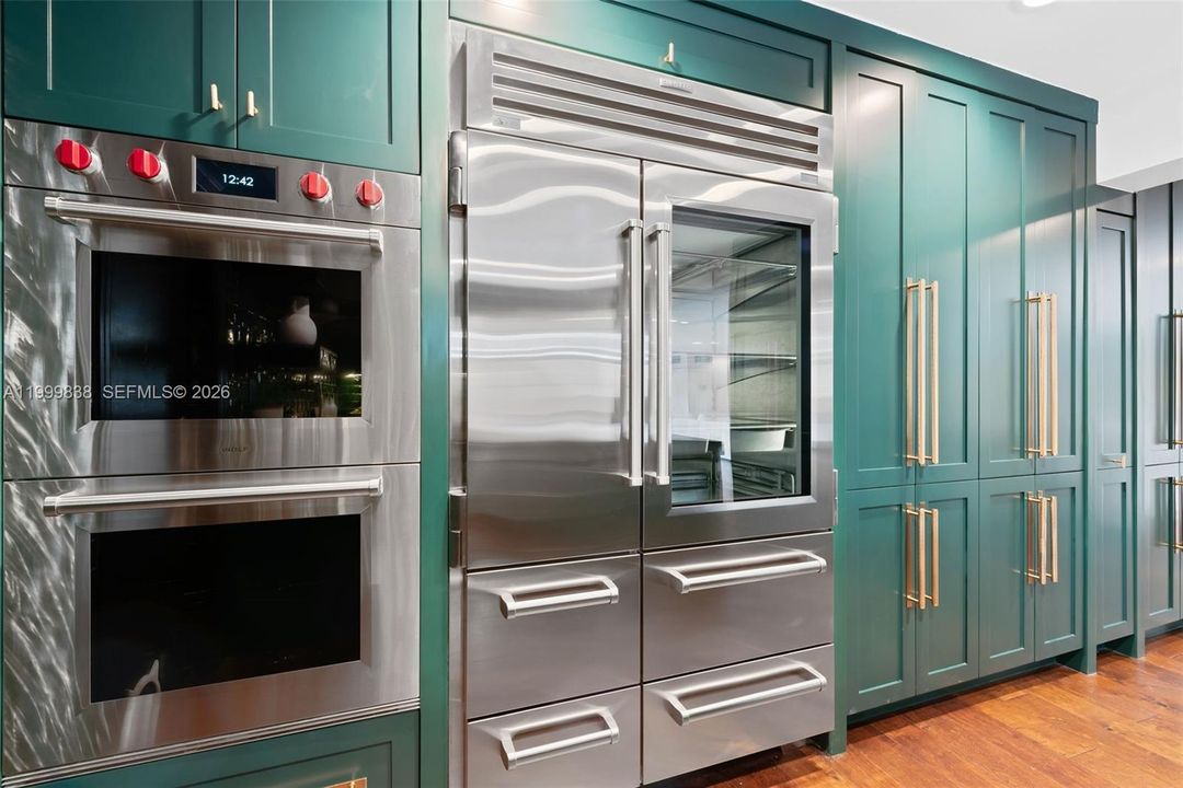 Expansive custom cabinetry throughout kitchen featuring fully integrated Sub Zero refrigerator & freezer drawers with double Wolf ovens.