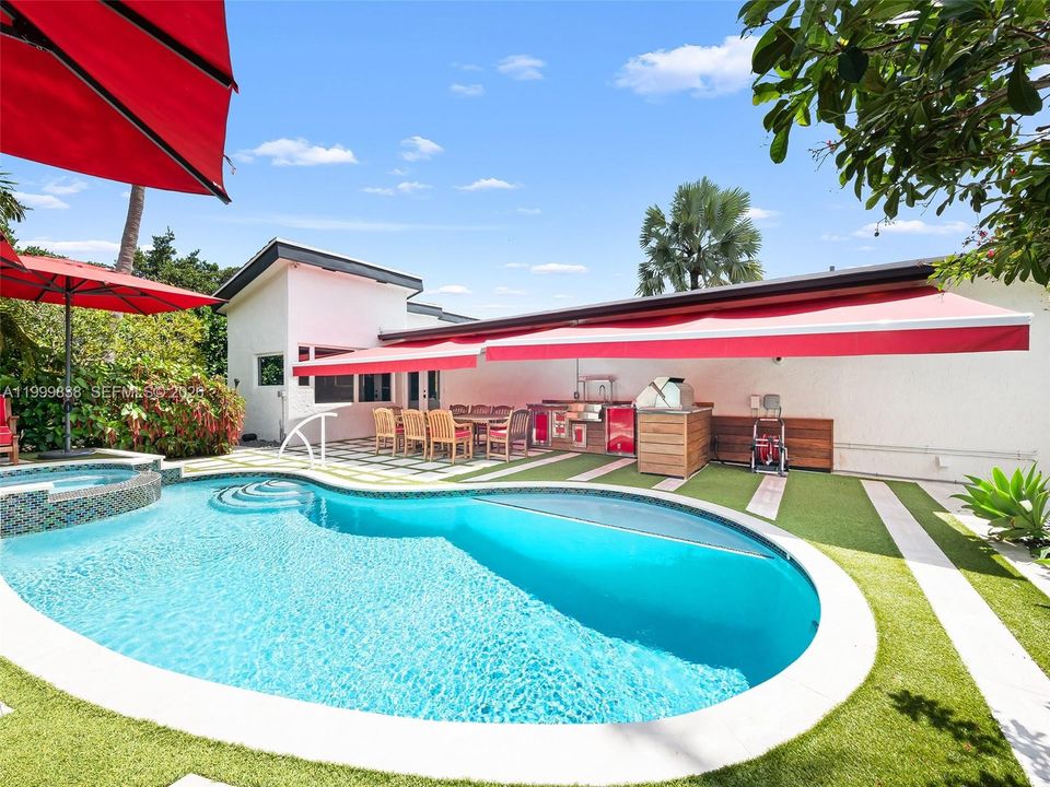 Resort style salt water pool featuring summer kitchen and retractable awnings