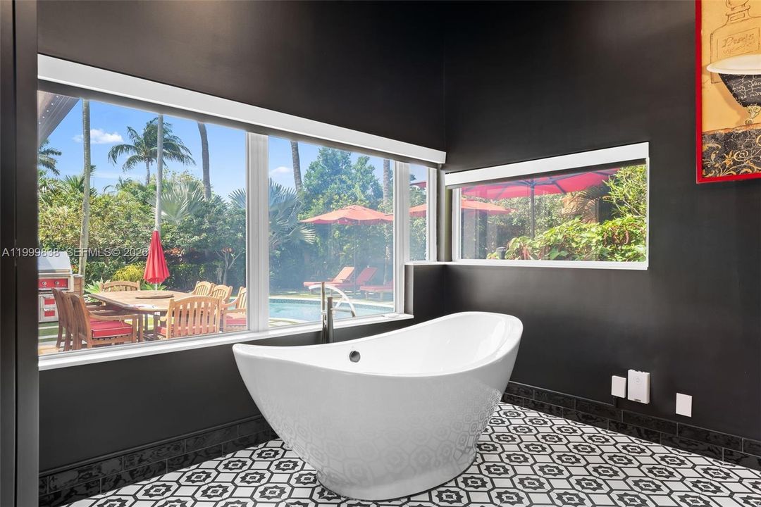 Primary en suite bath featuring stand alone soaking tub with views to outdoor oasis, large picture windows with privacy glass with the flip of a switch.