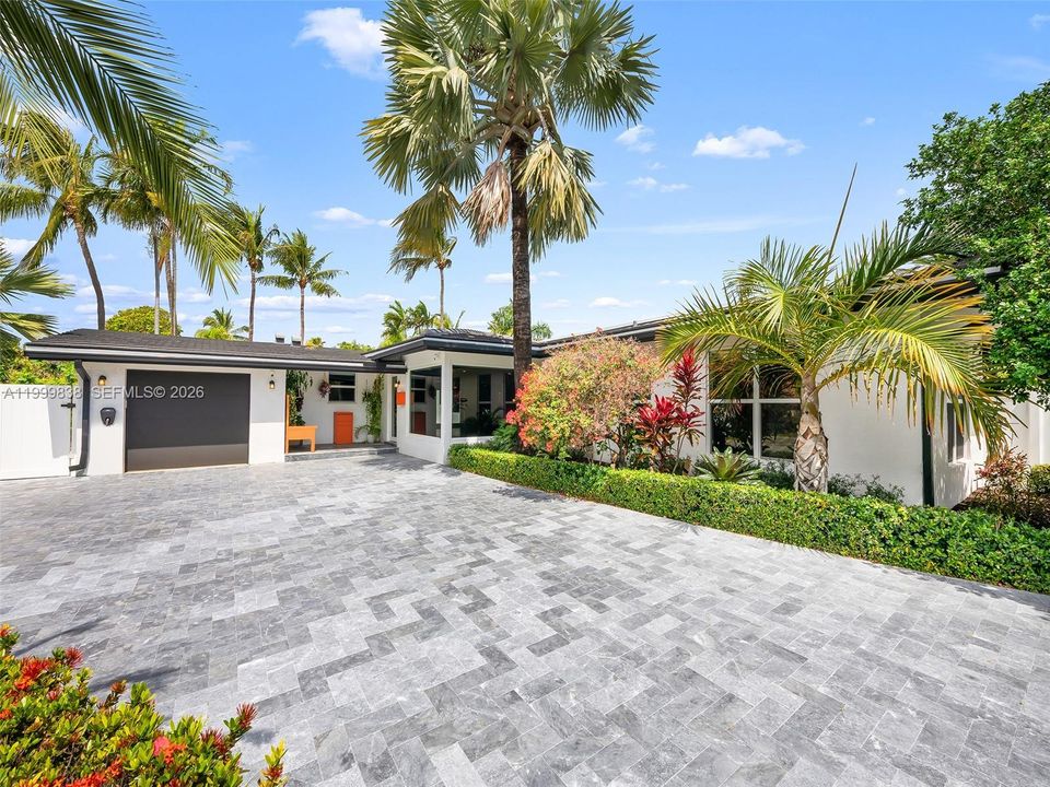 Expansive driveway, lush landscaping, one car garage and elegant entrance