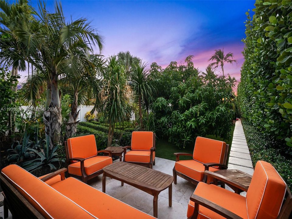 Outdoor oasis sitting area surrounded by lush landscaping