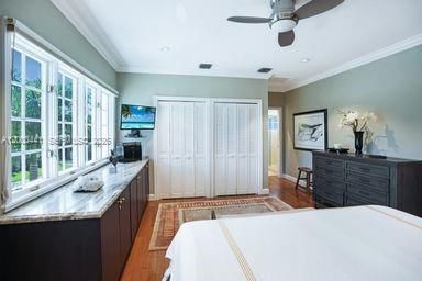 lLarge bedroom has built-in storage for granite top dresser.