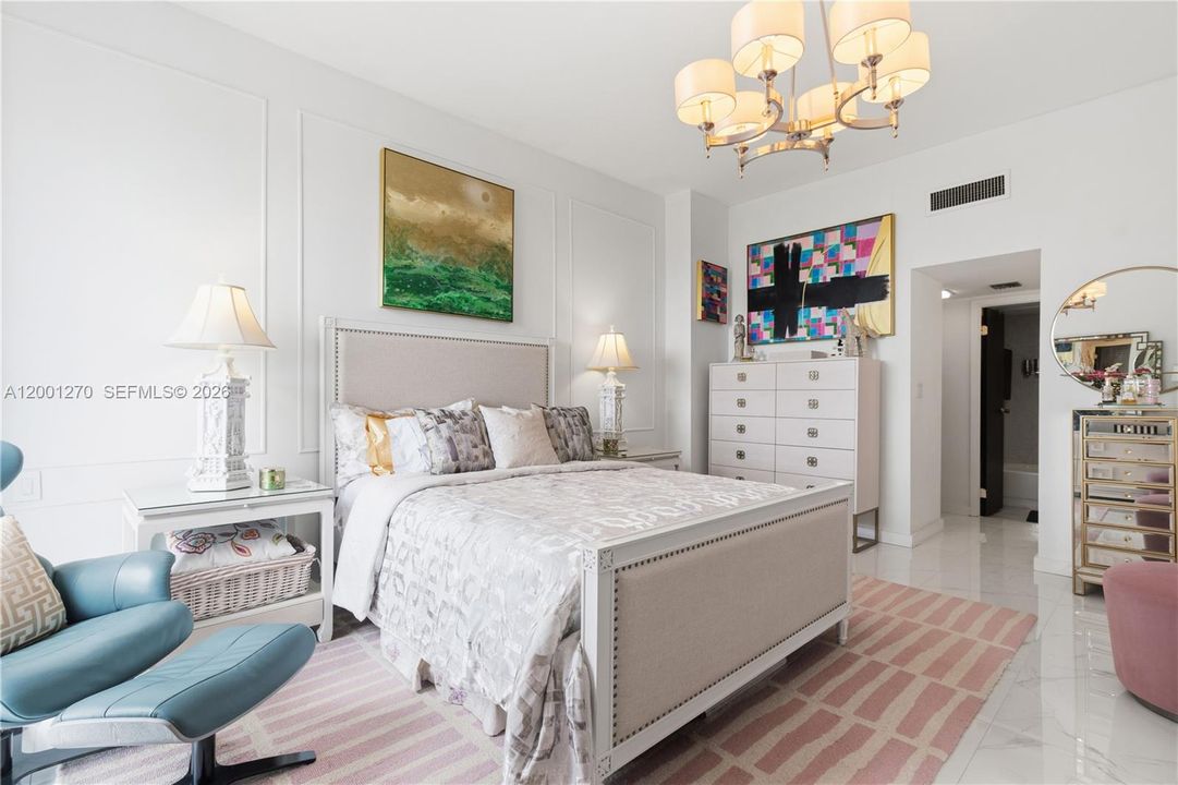 Spacious primary bedroom with high ceilings and natural light