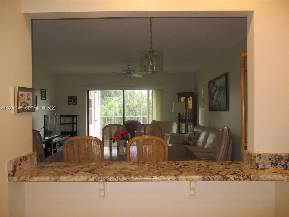 LARGE OPENING INTO THE DINING AREA WITH GRANITE COUNTERTOP