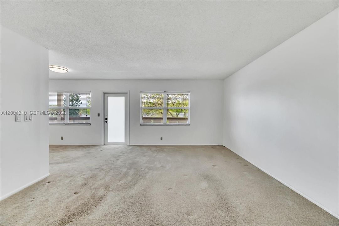 Living room alternate angle — wider view showing two windows flanking porch door