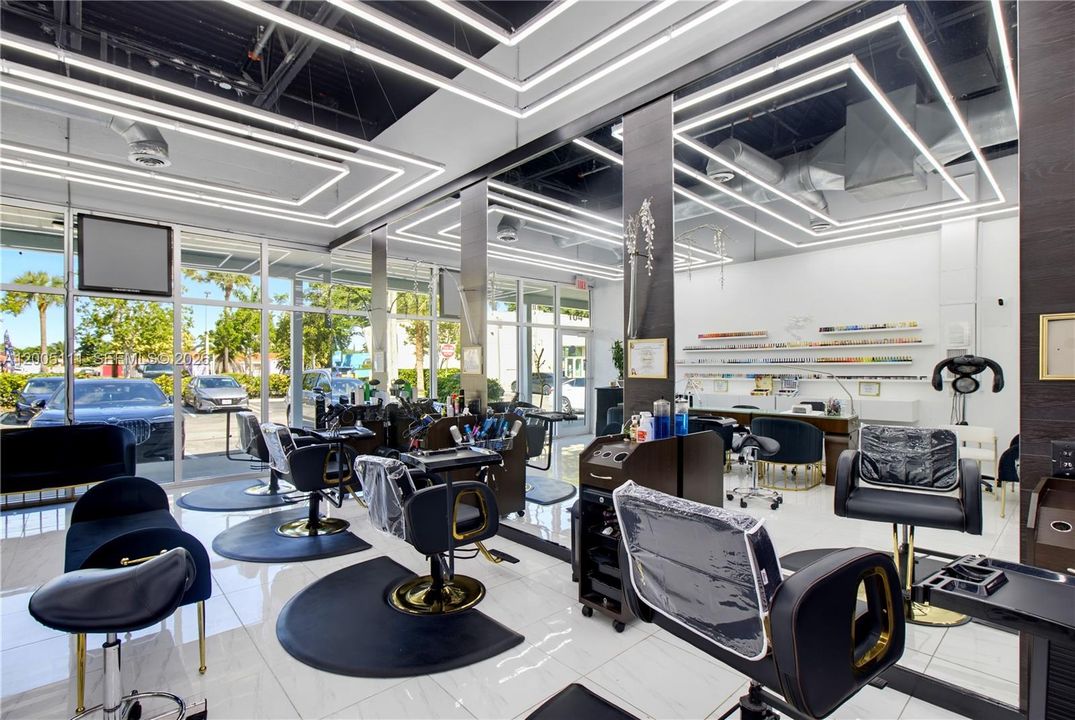 Commercial space featuring floor-to-ceiling windows, high-gloss tile flooring, custom geometric LED ceiling lighting, built-in display shelving, and an open-concept industrial ceiling design