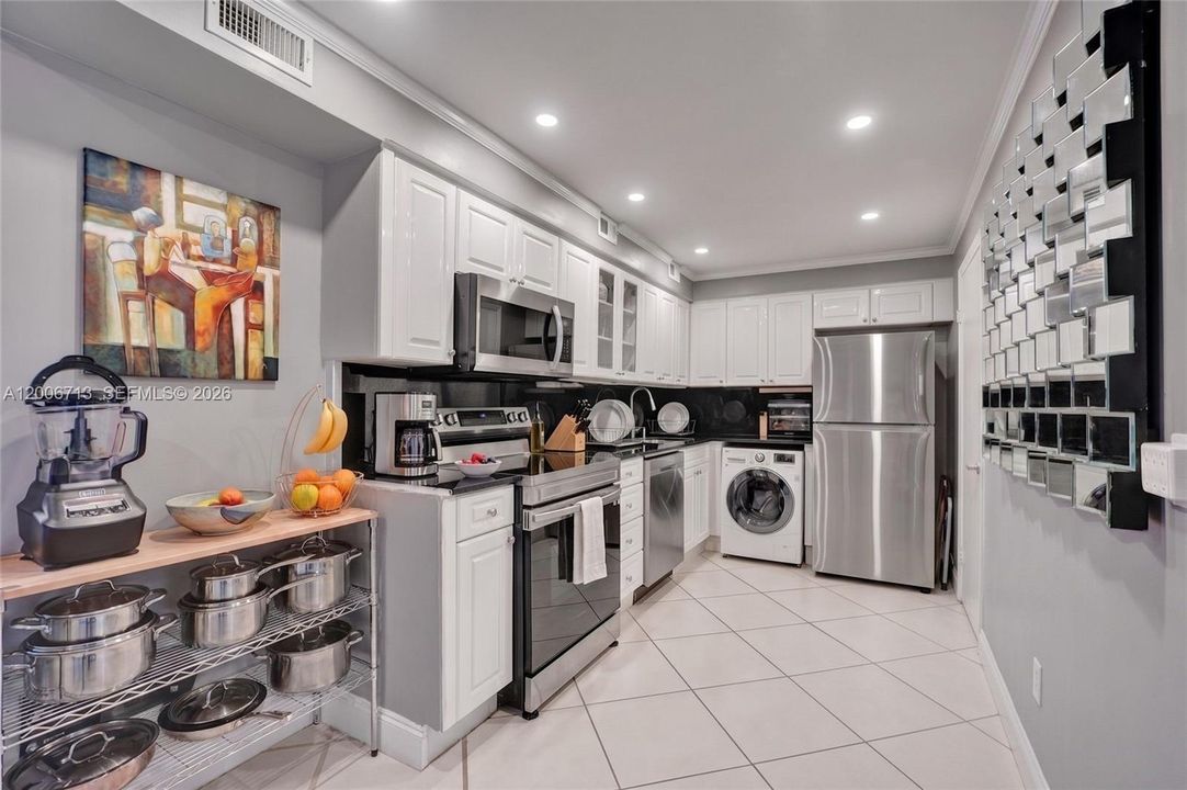 Large kitchen with white cabinets, black granite & SS appliances