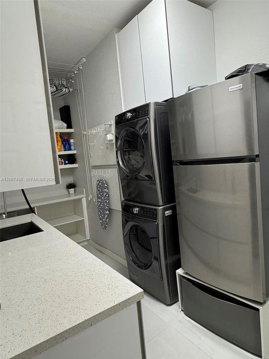 Underneath the extra refrigerator is a small washing machine