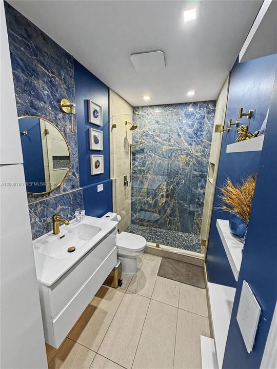 Beautifully renovated bathroom with designer blue-tile accent walls