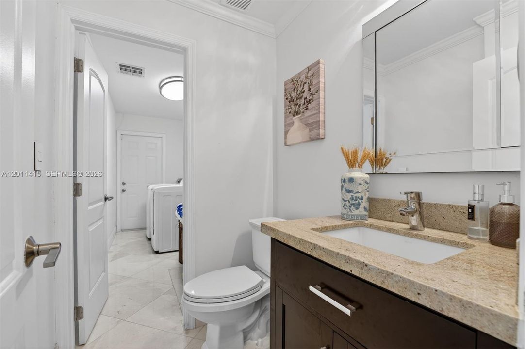 Half bathroom located off the living room, leading to the laundry room.