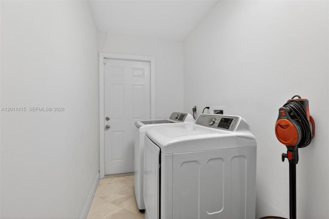 Laundry room offering extra storage space and a door leading to the exterior.