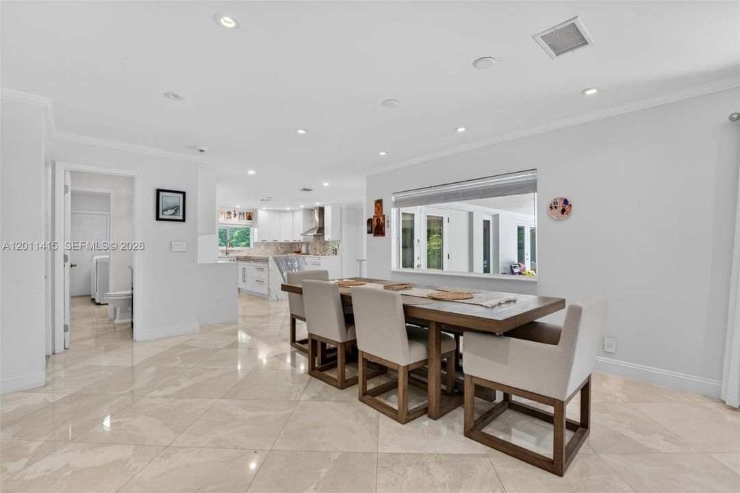 A large picture window fills the open dining and living space with natural light, creating a bright, airy feel throughout the home.