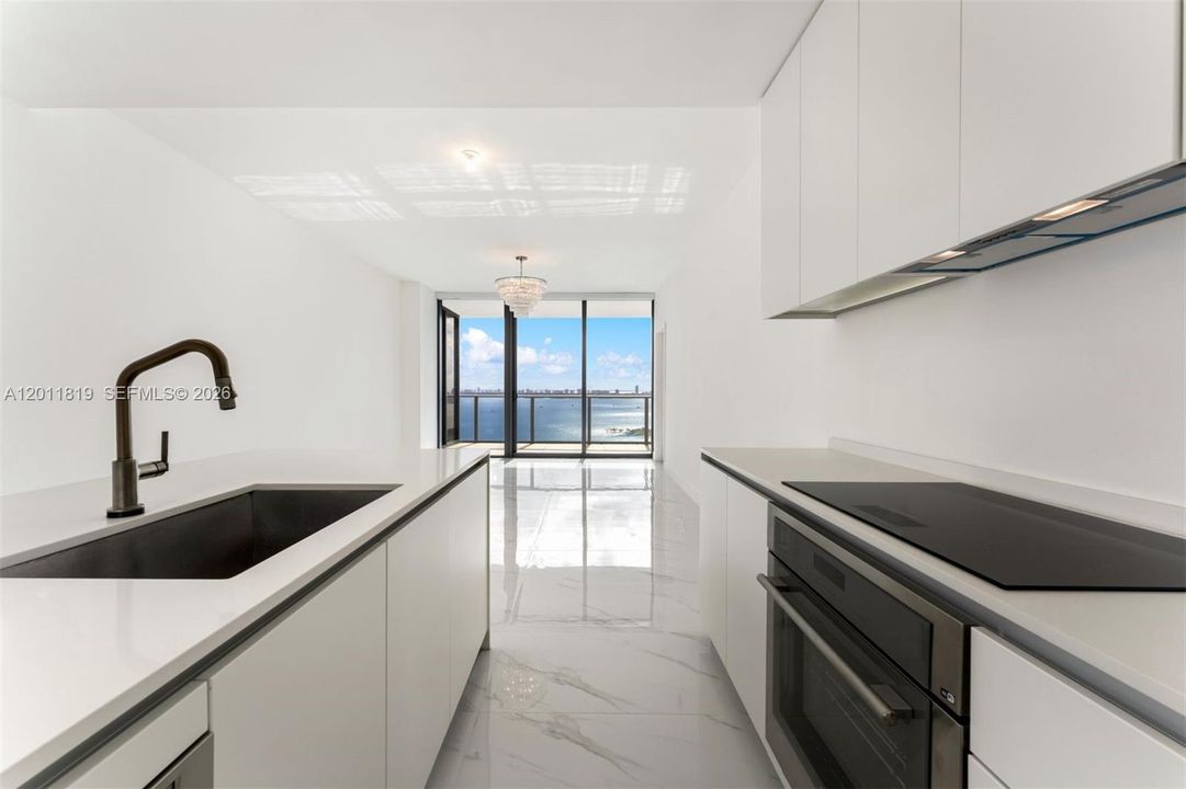 Modern chef’s kitchen equipped with custom Italian cabinetry, premium Miele appliances, integrated stone countertops, and a waterfall island perfect for entertaining.