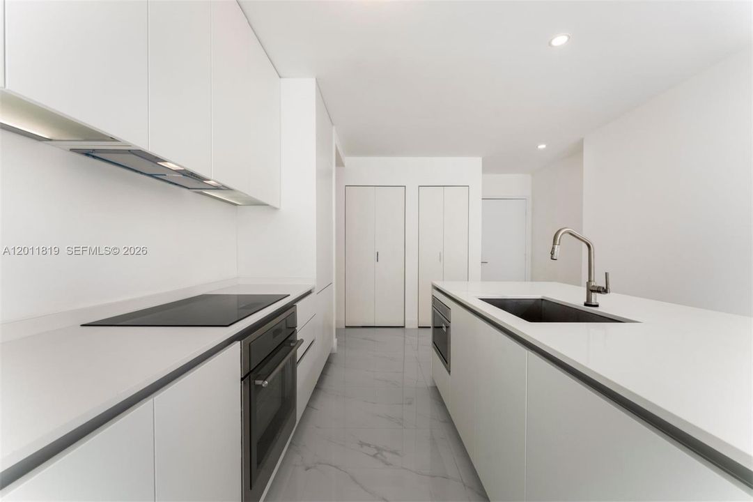 Modern chef’s kitchen equipped with custom Italian cabinetry, premium Miele appliances, integrated stone countertops, and a waterfall island perfect for entertaining.