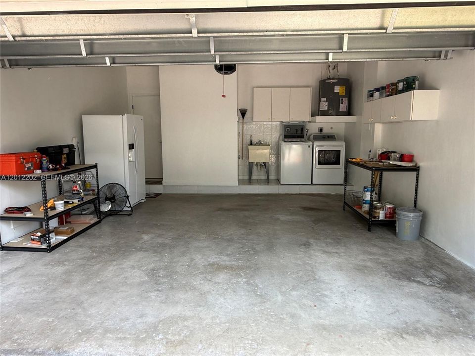 Two car garage with washer/dryer and laundry tub.