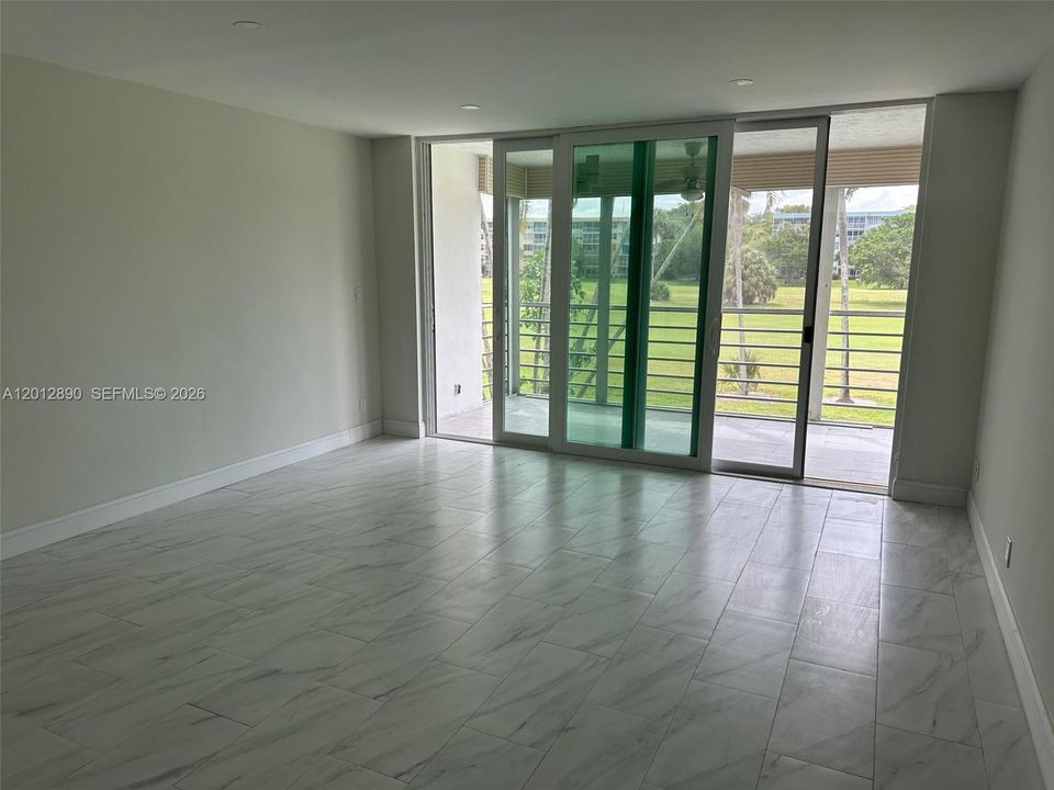Large living room opening to private terrace and view of golf course