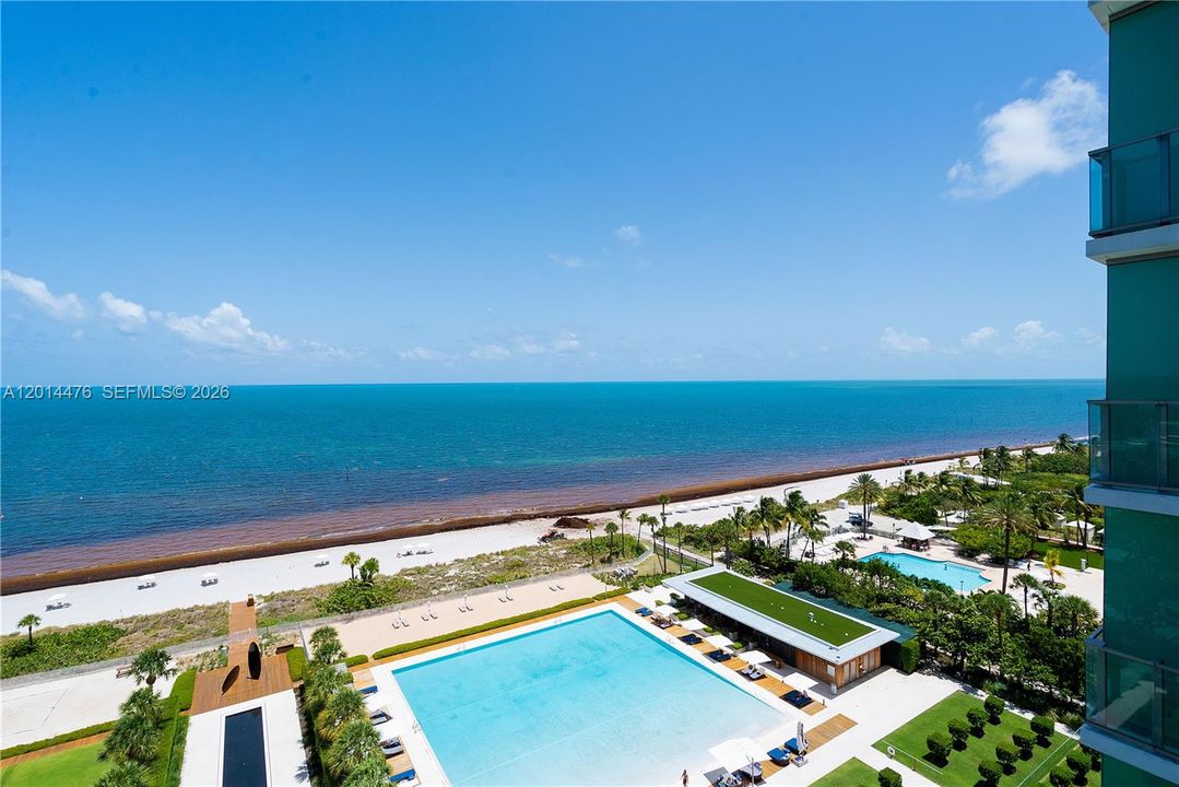 Ocean and Pool View – This elevated perspective overlooks the beachfront, resort-style pool deck, and open ocean beyond. Glass-sided architecture and bright blue water emphasize the property’s modern coastal atmosphere.