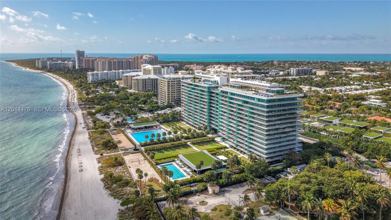 Aerial Beachfront Overview – A sweeping aerial view showcases the building’s beachfront setting, resort-style pool areas, landscaped grounds, and the shoreline stretching along the coast. The elevated perspective highlights the property’s connection to both the ocean and surrounding coastal neighborhood.