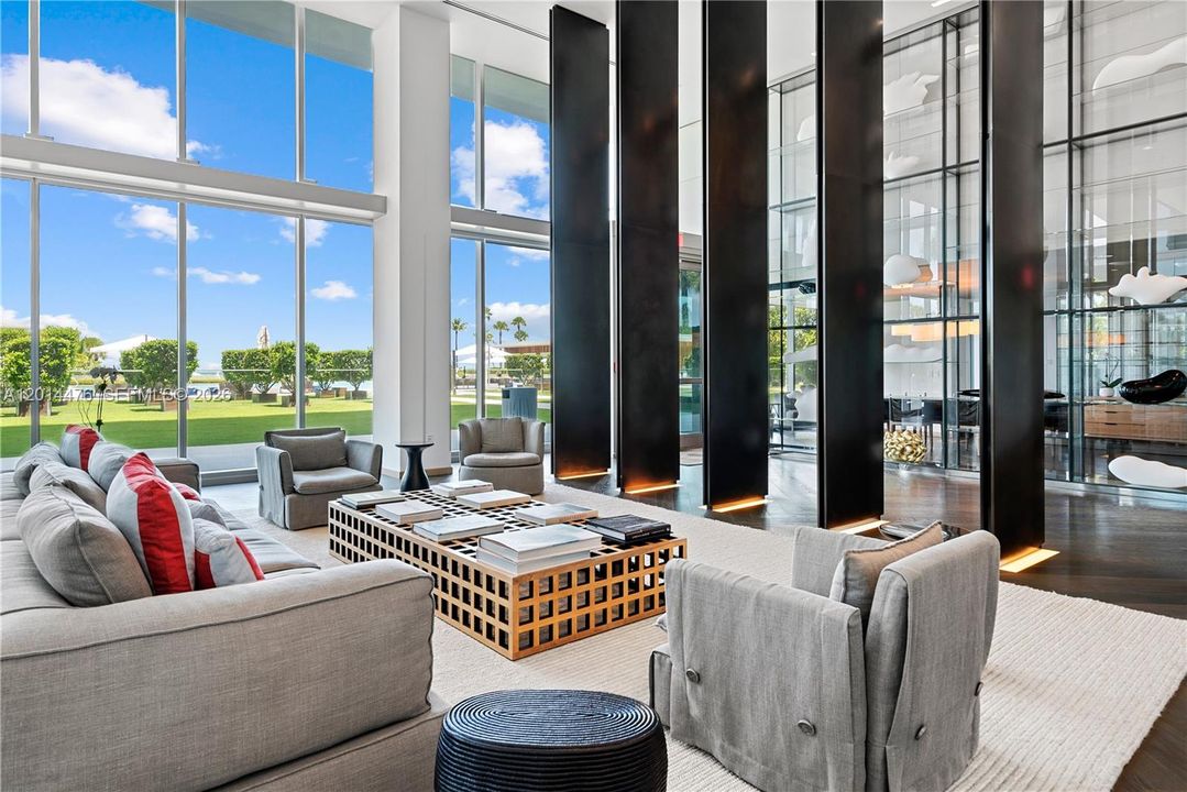 Lobby Lounge – A dramatic double-height lounge showcases floor-to-ceiling windows, sculptural black columns, and refined seating areas. The open design frames garden and ocean views while creating an impressive arrival experience.