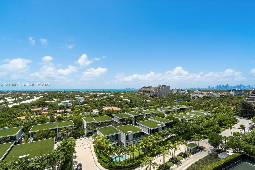 Balcony View – This view captures the home’s elevated outlook from the balcony, with sparkling water, lush greenery, and distant skyline views visible beyond the residence.