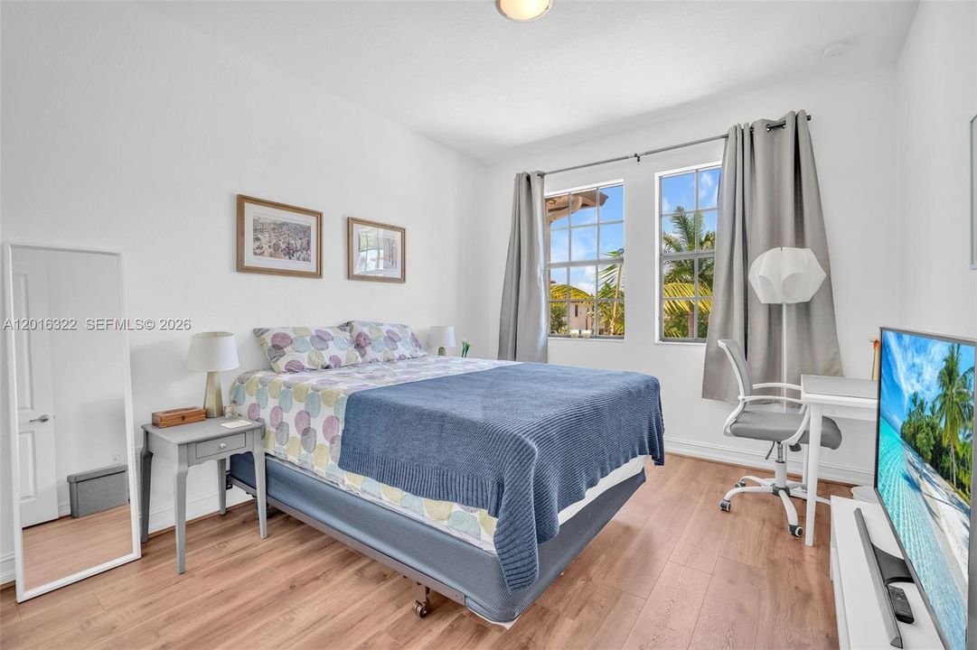 Well Lit Second Bedroom with Laminate Floors