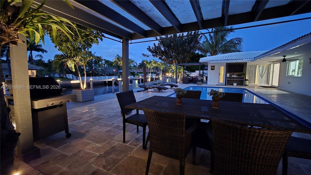 Elegant evening patio with waterfront ambiance, outdoor dining space, and luxury resort-style atmosphere.