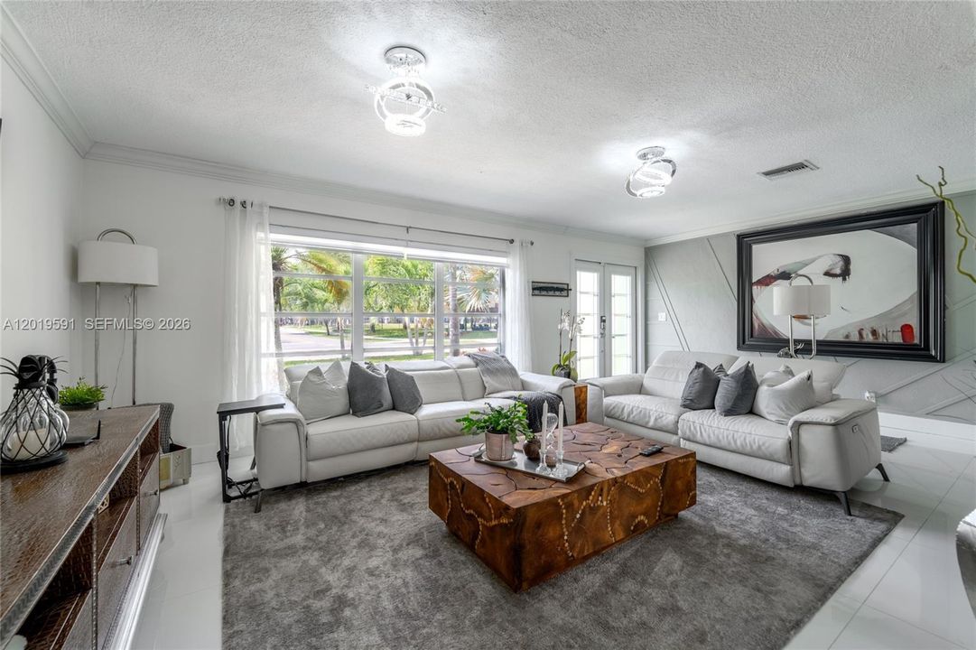 Spacious luxury living room with poolside views, stylish furnishings, and relaxing South Florida atmosphere.