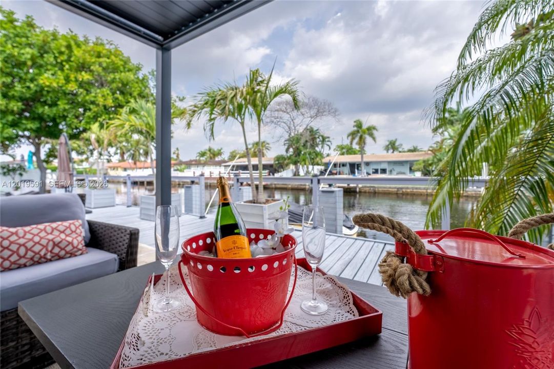 Waterfront outdoor lounge with canal views, tropical atmosphere, and relaxing resort-style seating area.