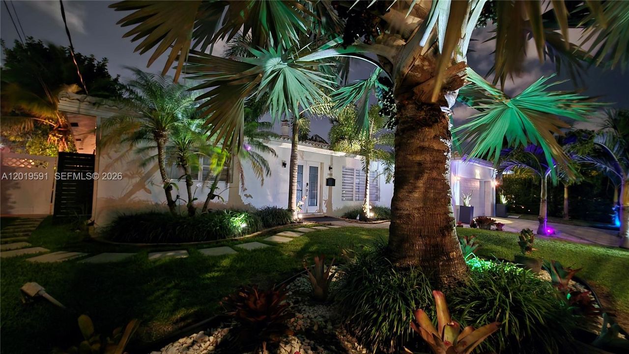 Tropical evening landscape lighting creating a private luxury resort atmosphere in a waterfront setting.
